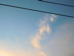 A cloud behind some power lines